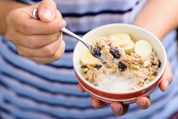 什锦麦片放在碗里用手拿着吃图片下载