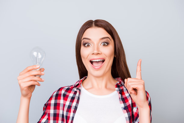 尤里卡!有一个想法!成功的概念。年轻可爱的女学生站在她的手拿一盏灯在纯背景休闲服装图片下载