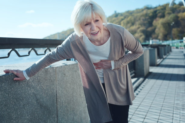 退休的女士由于剧烈的疼痛而弯腰驼背图片下载