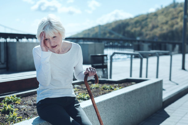 老年妇女在头痛时触摸太阳穴图片下载