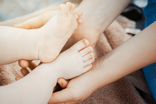 婴儿的脚在妈妈的手里。新生儿的小脚丫，幸福家庭的概念。照片的假色调图片下载