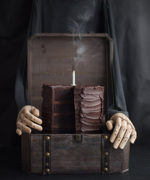 巧克力蛋糕和蜡烛在一个木盒子。木偶的风格图片下载