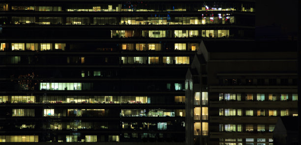 在现代化的玻璃墙合作办公室加班。图片下载