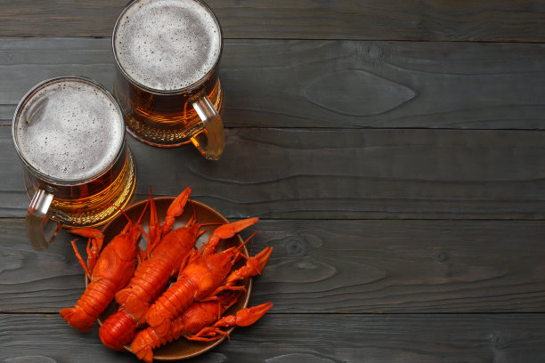 深色木质背景上的小龙虾玻璃啤酒。啤酒厂的概念。啤酒的背景。顶部视图与复制空间图片下载