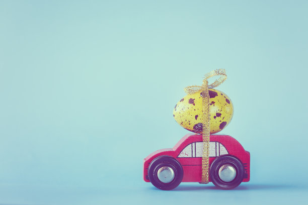 复活节概念-红色的玩具车载着黄色的蛋。健美的图片图片下载