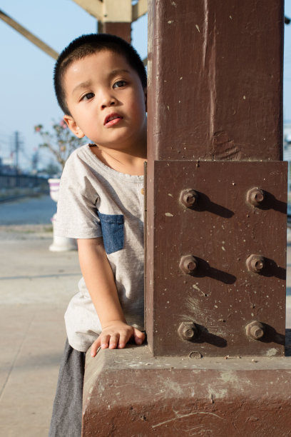 孩子躲在一根杆子后面图片下载