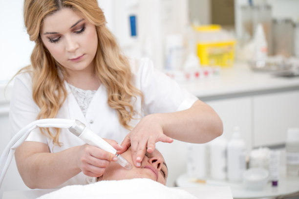 皮肤科医生给一名成年妇女进行微晶磨皮治疗图片下载