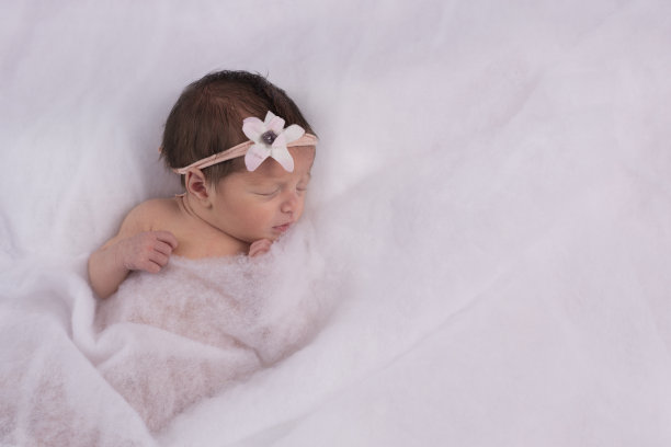 白色毯子下的新生婴儿。图片下载