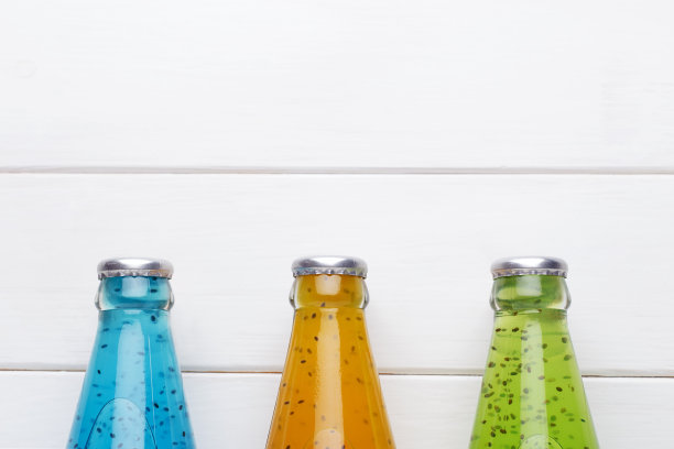 白色木制背景与三瓶奇亚种子饮料。图片下载