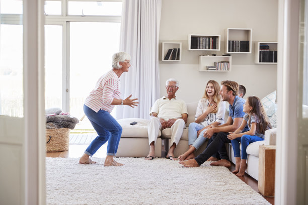多代家庭坐在沙发上玩猜字游戏素材图片