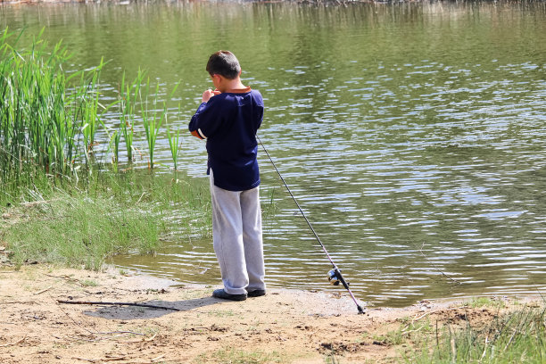 一个男孩正在为钓鱼准备鱼钩图片下载