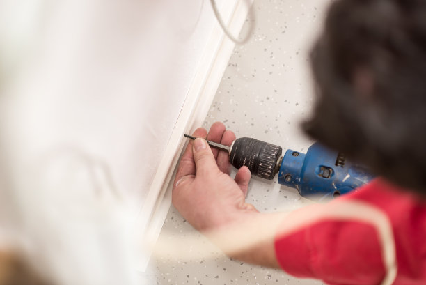 一个工人在墙上钻孔的俯视图图片下载