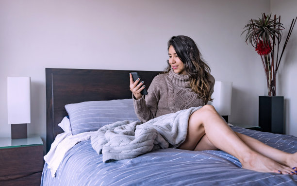拉丁女人在卧室里看手机，第九张照片图片下载