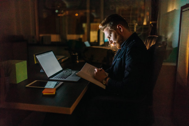 在办公室工作到深夜的商人图片下载