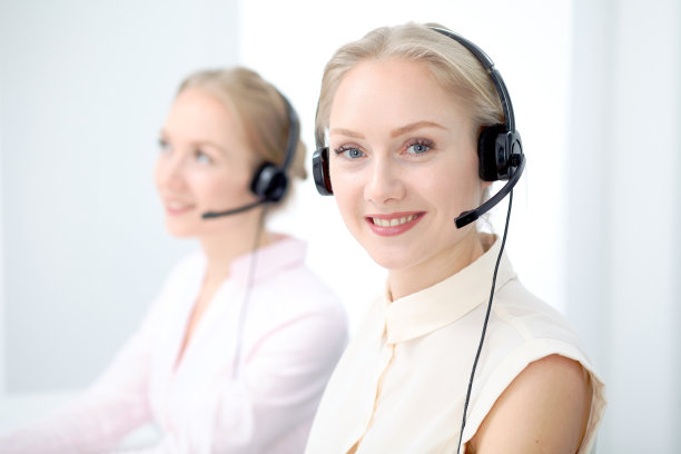 明亮的呼叫中心图像。关注戴着耳机的年轻美女图片下载