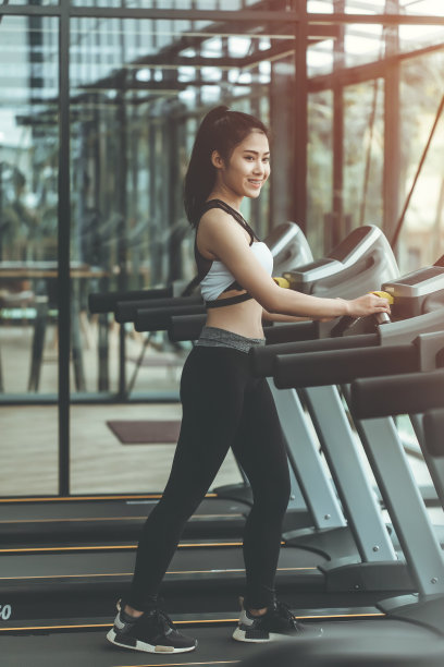 在健身房跑步机上跑步的女人图片下载