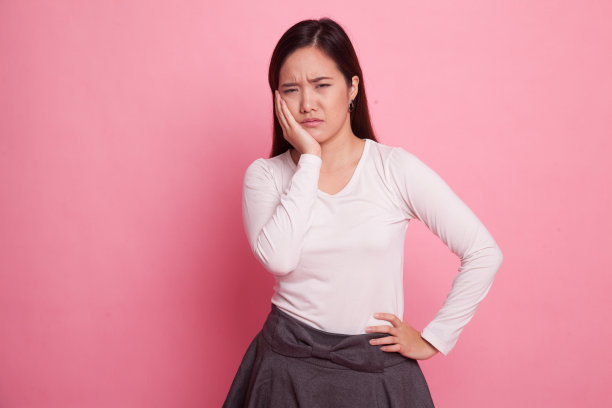 年轻的亚洲妇女牙痛。素材图片