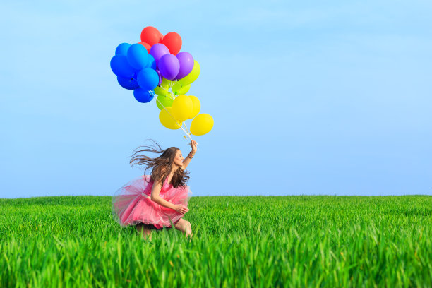 兴高采烈的年轻女子拿着彩色气球跑着图片下载