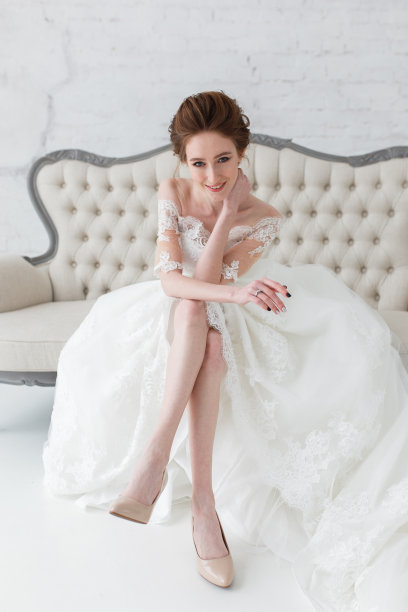 肖像美丽幸福的新娘坐在沙发上，特写垂直镜头图片下载