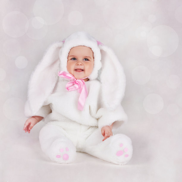 一个穿着白色兔子服装的小孩。孩子的微笑。图片下载