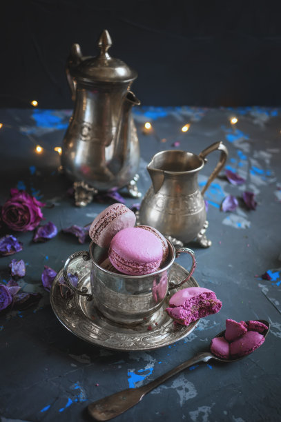 银质金属杯上新鲜烘焙的杏仁蛋白杏仁饼，木质背景上有灯光的散焦。有选择性的重点。素材图片