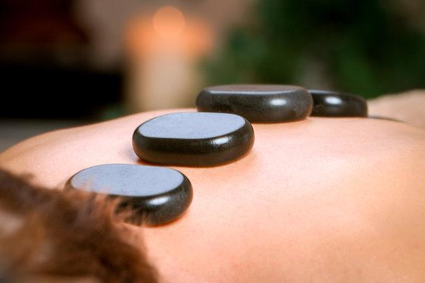 年轻男子接受肩部和背部按摩的治疗师在水疗中心图片下载