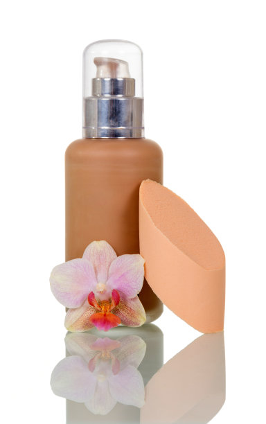 瓶内装有遮瑕膏，海绵敷用，兰花花孤立于白色图片下载