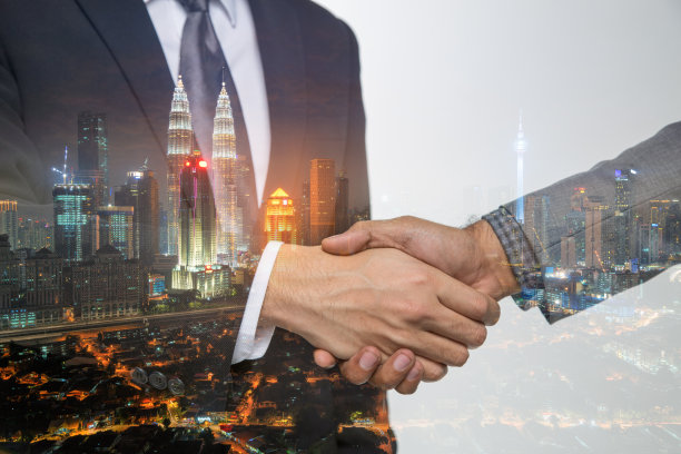 双曝光的一个商人握手在吉隆坡城市摩天大楼马来西亚的背景。图片下载