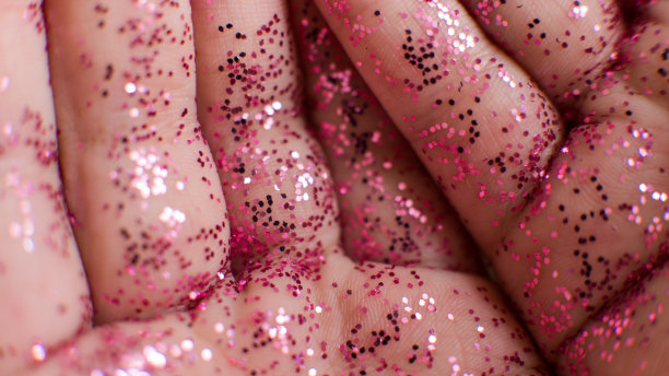 儿童手上的粉色闪光特写微距照片，时尚美容行业图片下载