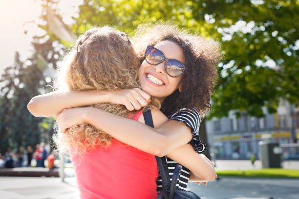 快乐的女孩们在城市里散步时拥抱图片下载