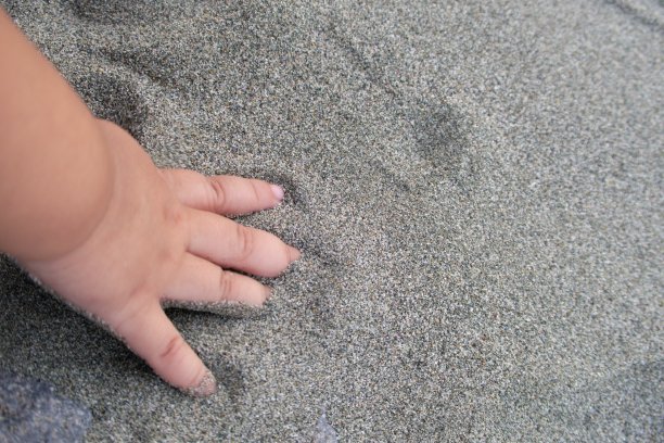 婴儿的手在沙滩上图片下载