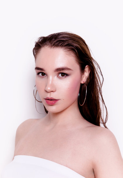 美丽的年轻女子肖像与专业的自然看起来化妆戴圈耳环图片下载