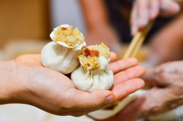 手持烧麦、粽子，中国传统美食素材图片