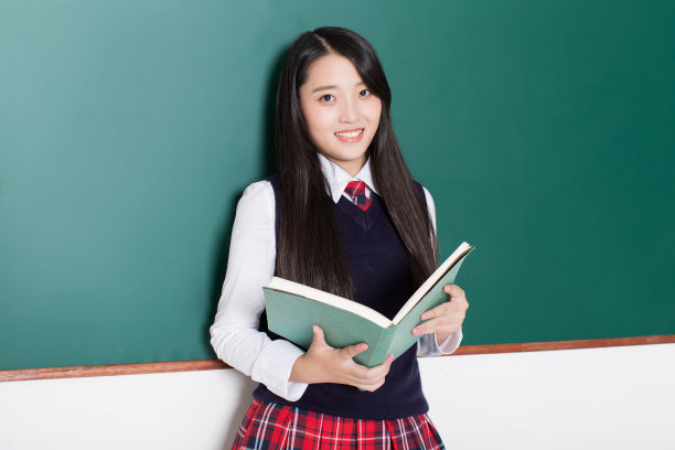 漂亮的少女拿着书看着相机素材图片