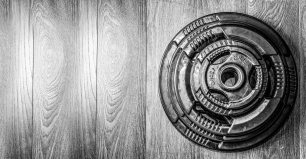 在健身房地板上放置重杠铃板，准备进行力量健美锻炼图片下载