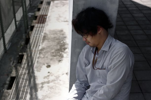 侧面的压力抑郁的年轻亚洲商人遭受严重的抑郁症。图片下载