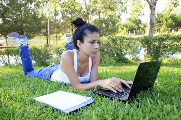 坐在草地上使用笔记本电脑图片下载