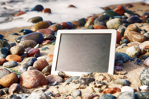 黑板躺在沙滩上的石头之间图片下载