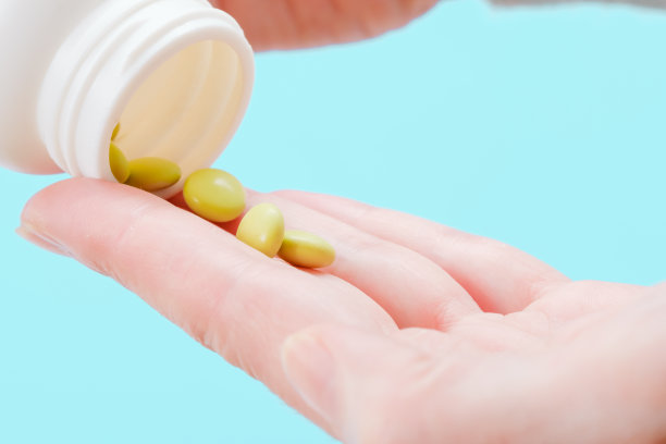 近距离看，女人把药丸倒出瓶子。医药和保健。图片下载