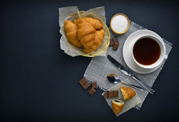 巧克力牛角面包和一杯咖啡。早....休息。木质背景上的新鲜糕点。前视图。图片下载