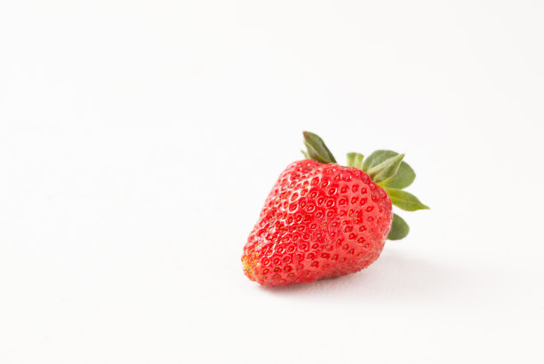 白色桌子上的成熟红色草莓素材图片