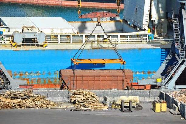 港口起重机下的散装货船和火车图片下载