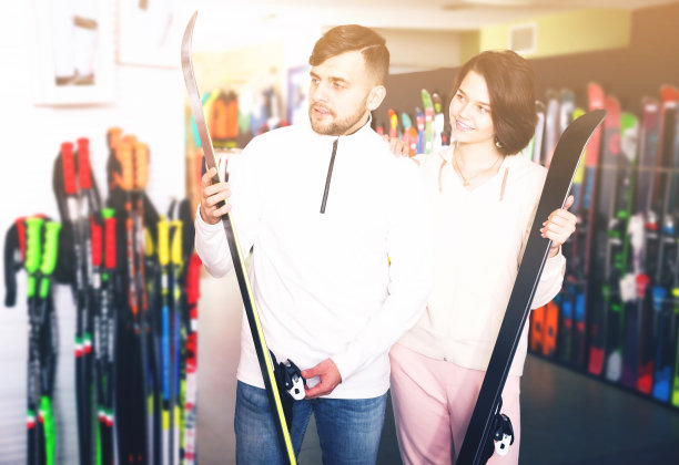 情侣在商店挑选滑雪板图片下载