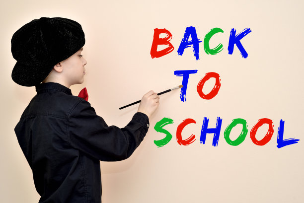 年轻的画家用毛笔在墙上写回学校图片下载