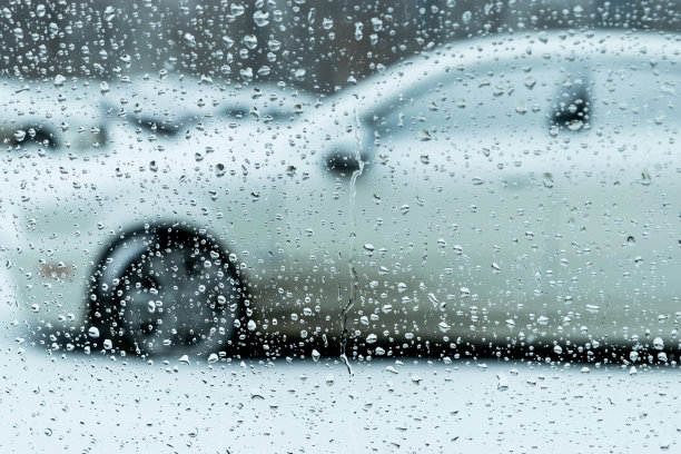 水滴落在车窗上，背景模糊不清图片下载