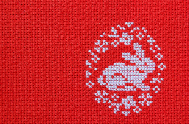 复活节兔子在一个花蛋绣在红色织物。图片下载