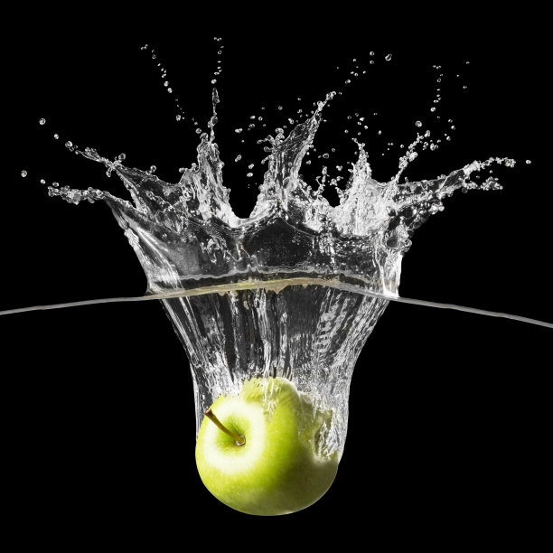 在黑色的背景下，新鲜的绿苹果飞溅到清澈的水中图片下载
