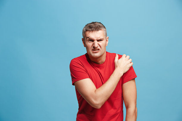 那个年轻人被肩膀的疼痛压倒了素材图片