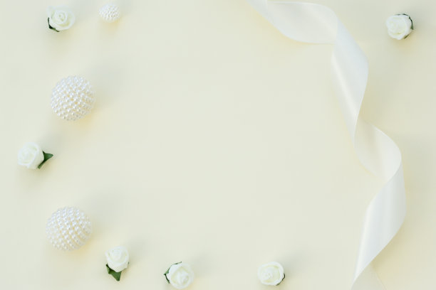 风格的库存图片。女性婚礼桌面模型。白玫瑰，缎带，精致的米色背景珠子。副本的空间。前视图。图片博客。图片下载