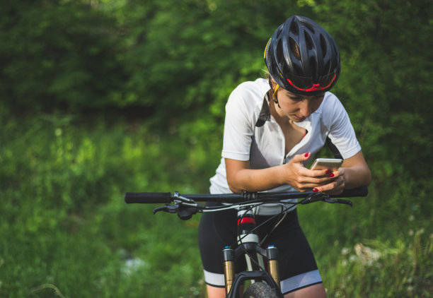 运动女性，自行车手，用智能手机导航图片下载